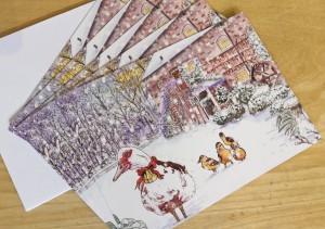 Five Christmas cards laid out in a fan. The card has an illustrated picture of The Watermill and some ducks in snow on the front.