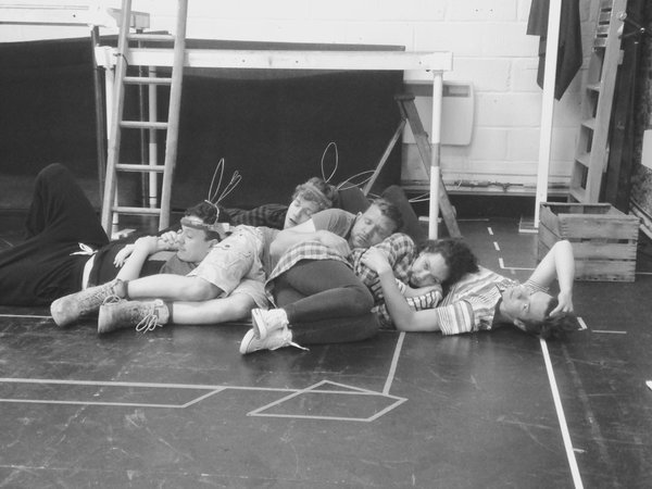 A black and white photo from the rehearsals of Watership Down. The cast are lying on the floor.