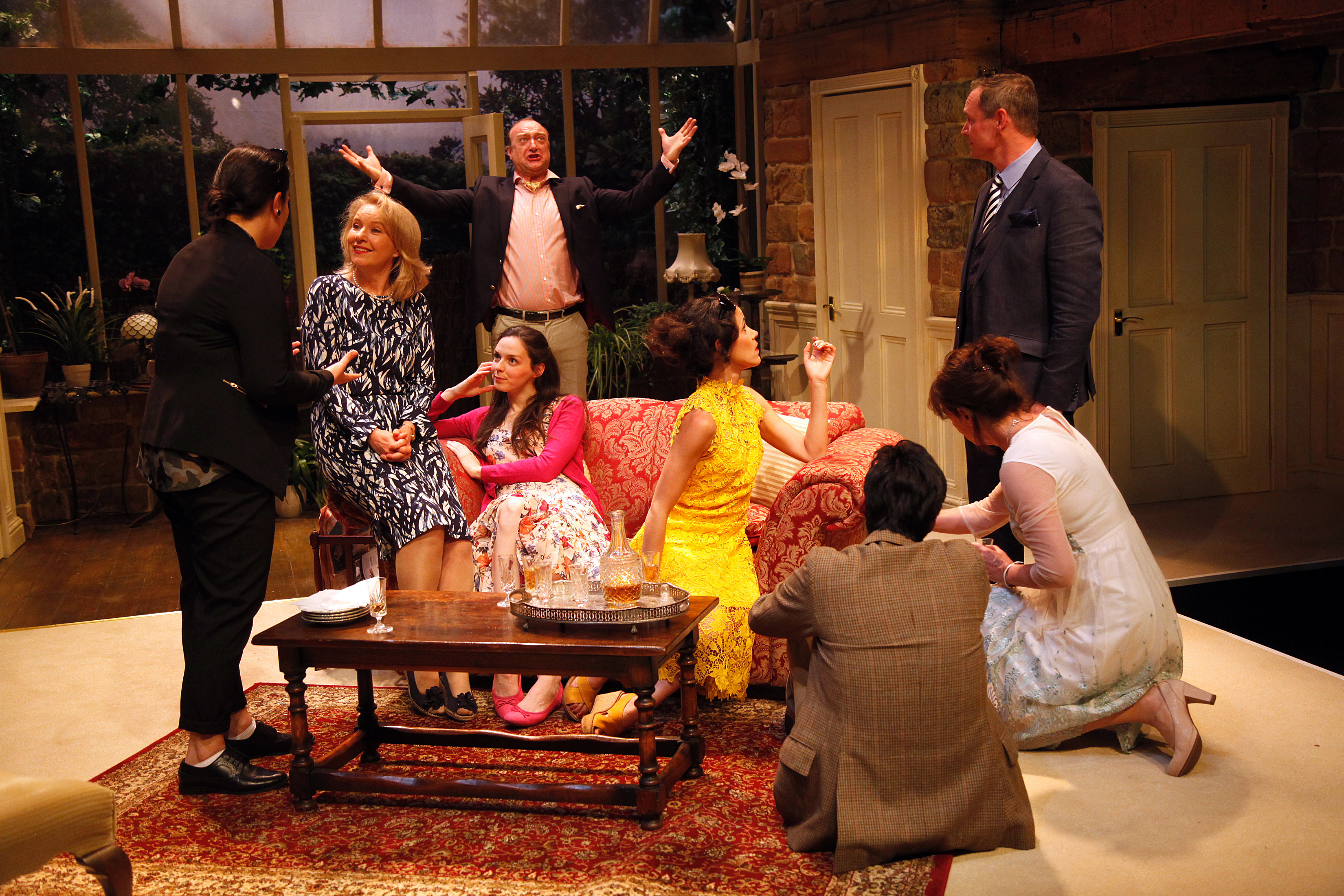 A photograph from House and Garden. Cast are gathered around a sofa.